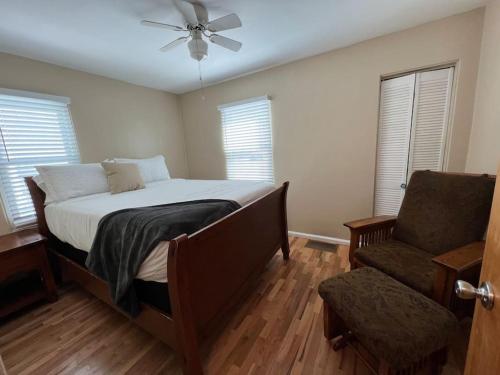 um quarto com uma cama e uma cadeira e uma ventoinha de tecto em Snug, neighborly home perfect for your small group em Billings