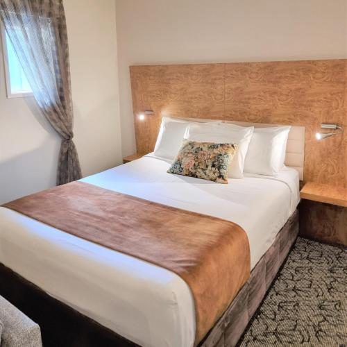 a bedroom with a large white bed with a window at Adina Citylife Wellington in Wellington