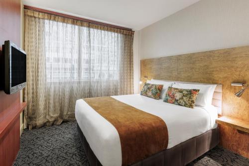a hotel room with a large bed and a television at Adina Citylife Wellington in Wellington
