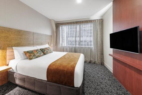 a hotel room with a bed and a flat screen tv at Adina Citylife Wellington in Wellington
