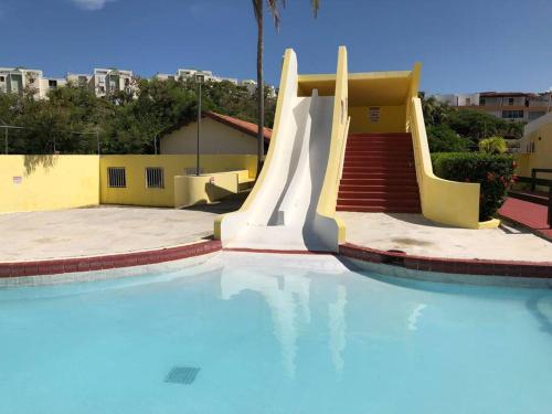 a swimming pool with a slide in a building at Casa Rosado @ Villa Marina Fajardo Pool Yunque in Fajardo