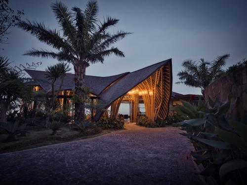 a house with a black roof and a palm tree at Elevate Bali in Munduk