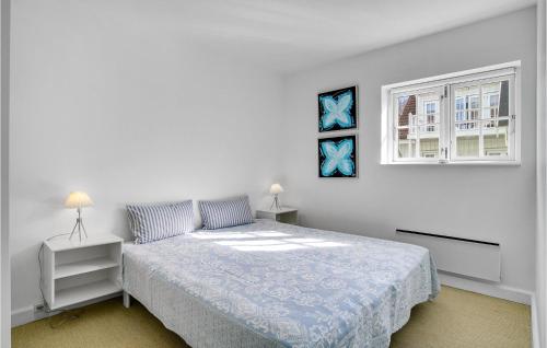 een witte slaapkamer met een bed en een raam bij Cozy Apartment In Nykbing Sj With Outdoor Swimming Pool in Rørvig