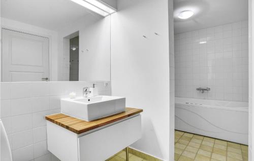 een witte badkamer met een wastafel en een bad bij Cozy Apartment In Nykbing Sj With Outdoor Swimming Pool in Rørvig