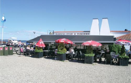 a restaurant with tables and chairs and red umbrellas at Lake Front Apartment In Nykøbing Sj in Rørvig