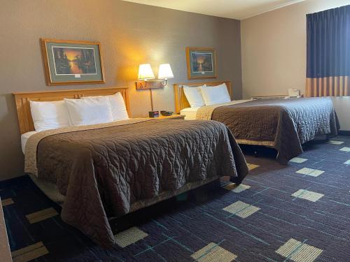 a hotel room with two beds and two lamps at Walker Hotel in Walker