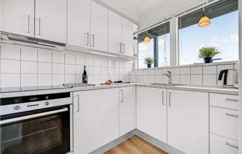 a white kitchen with white cabinets and a sink at 1 Bedroom Awesome Apartment In Ebeltoft in Ebeltoft