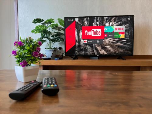 a tv sitting on a table with two remote controls at NEW 6pax 3BR Sunrise view 100m Attractive Places Kea Farm in Cameron Highlands