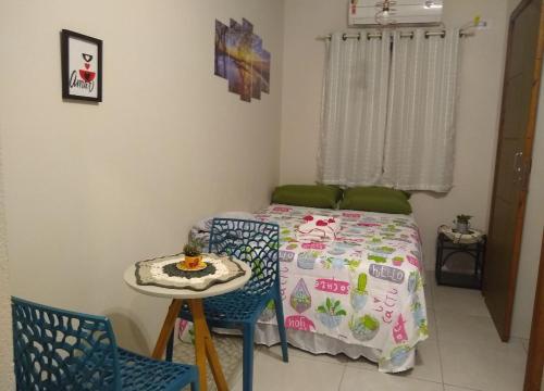 um quarto com uma cama, uma mesa e cadeiras em Praia do Rosa loft com cozinha em Imbituba