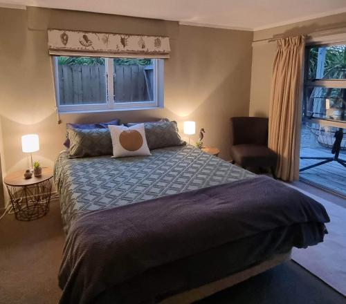 a bedroom with a large bed and a window at HarbourView Hotel in Raglan