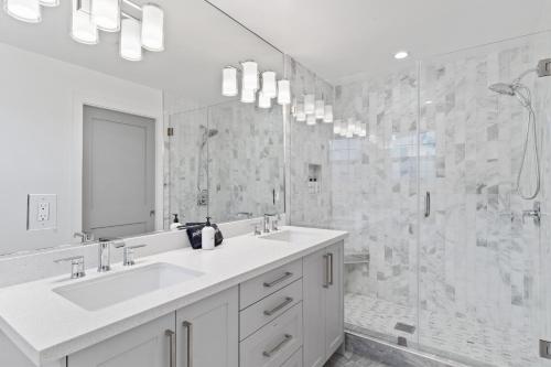 a white bathroom with a sink and a shower at @ Marbella Lane - 3BR w/sweeping views of Bay Area in San Mateo