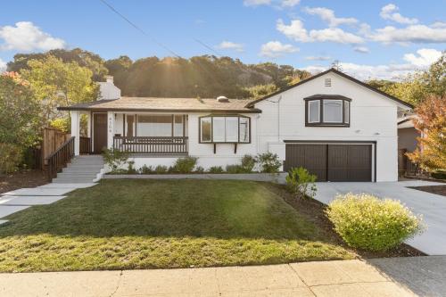 a white house with a large yard at @ Marbella Lane - 3BR w/sweeping views of Bay Area in San Mateo