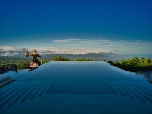 a large swimming pool with a view of the mountains at Elevate Bali in Munduk