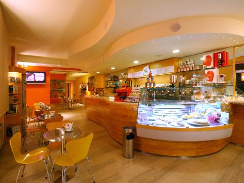 a restaurant with a counter and tables and chairs at Albergo Ristorante Corsini in Pavullo nel Frignano