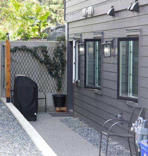 a patio with two chairs next to a house at M&M's Maple Bay Mountain Guesthouse in Duncan