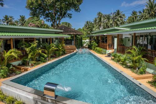 a swimming pool in front of a house at The Joy Beach Villas in Hinkong