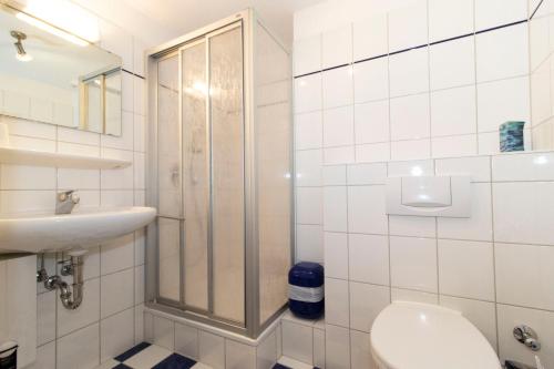 a bathroom with a shower and a toilet and a sink at Kurpark-Residenz 142 in Döse