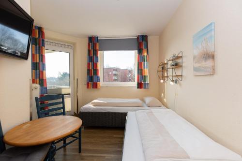 een kleine kamer met 2 bedden en een tafel bij Kurpark-Residenz 123 in Döse