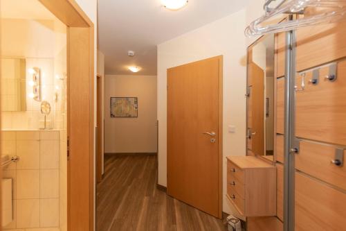 een badkamer met een houten deur en een kast bij Kurpark-Residenz 123 in Döse