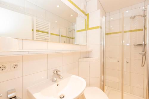a white bathroom with a sink and a shower at Lord Nelson 215 in Döse