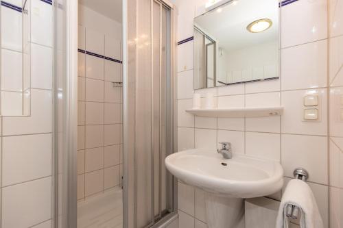 Baño blanco con lavabo y espejo en Kurpark-Residenz 141 en Döse