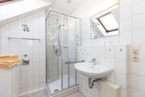 uma casa de banho branca com um lavatório e um chuveiro em Trafalgar 349 em Döse