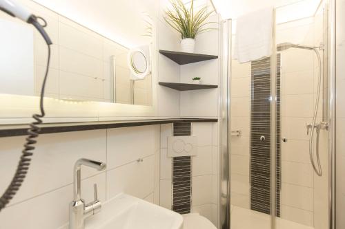 a bathroom with a sink and a shower and a mirror at Lord Nelson 119 in Döse