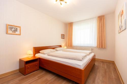 een slaapkamer met een groot bed en een raam bij Kurpark-Residenz 234 in Döse