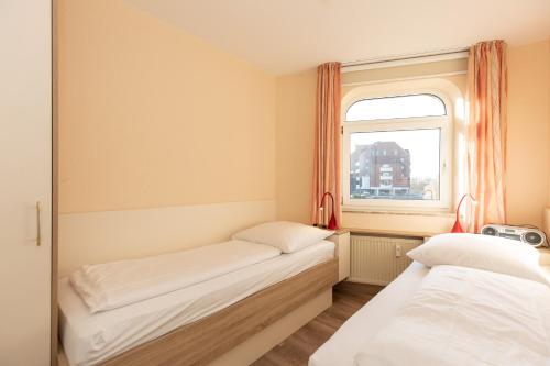 two beds in a room with a window at Trafalgar 123 in Döse