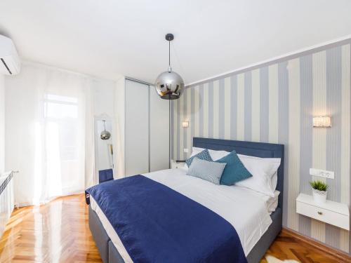 ein Schlafzimmer mit einem blauen und weißen Bett mit blauen Kissen in der Unterkunft Villa Beauty Luxury Vodice in Vodice