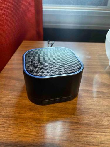 a black speaker sitting on top of a wooden table at Dartt's Park Flat in Owatonna