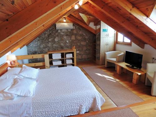 1 dormitorio con 1 cama y TV en el ático en Villa Peace, en Jesenice