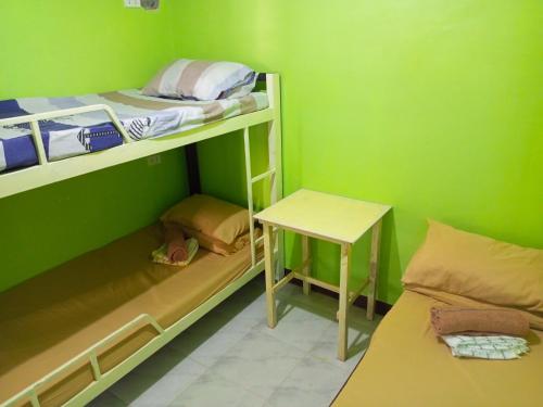 a small room with two bunk beds and a table at Marbeth Inn in Coron