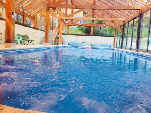 a large swimming pool in a building with a wooden ceiling at Encanto del Rio in Villa La Angostura