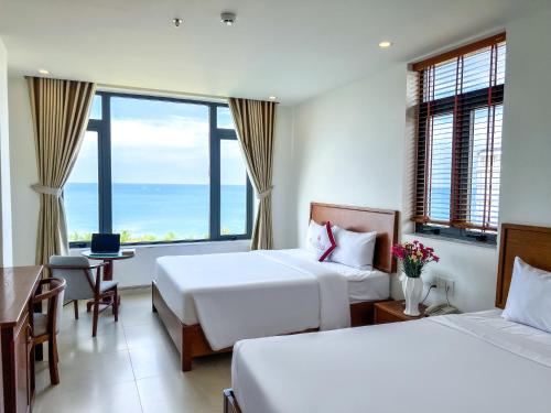 een hotelkamer met 2 bedden en uitzicht op de oceaan bij Homestead Seaview Phú Quốc Hotel in Phu Quoc