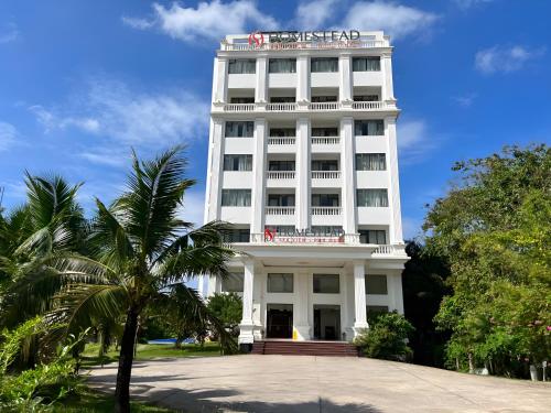 a white building with a red sign on it at Homestead Seaview Phu Quoc Hotel in Phu Quoc