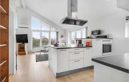 a kitchen with white cabinets and a black counter top at Cozy Home In Rudkøbing With Wifi in Spodsbjerg