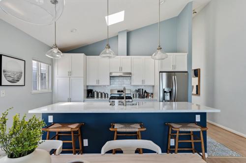 a kitchen with white cabinets and a blue wall at @ Marbella Lane – Home with Majestic Ocean Views in Pacifica