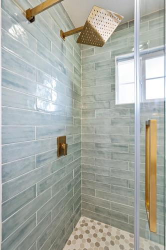a bathroom with a shower with blue tiles at @ Marbella Lane – Home with Majestic Ocean Views in Pacifica