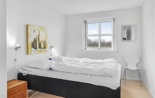 a white bedroom with a bed and a window at Cozy Home In Rudkøbing With Wifi in Spodsbjerg