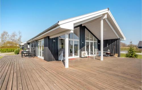 ein Haus mit einer großen Holzterrasse in der Unterkunft Cozy Home In Rudkøbing With Wifi in Spodsbjerg