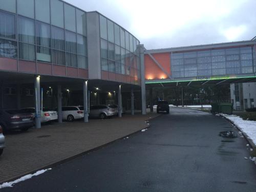 a large building with cars parked in a parking lot at Hotel Forma in Piła