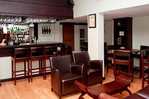 a bar with leather chairs and a bar counter at InnJoy Boutique Hotel in Centurion