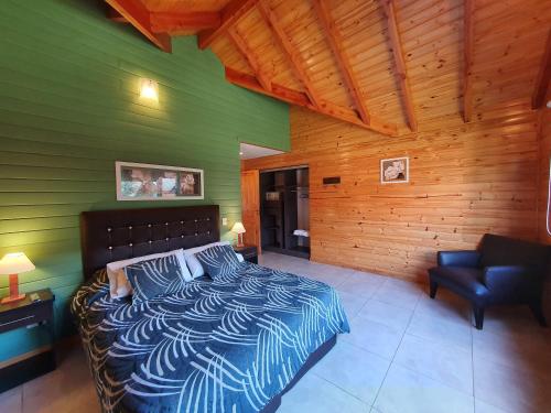a bedroom with a bed and a green wall at Encanto del Rio in Villa La Angostura
