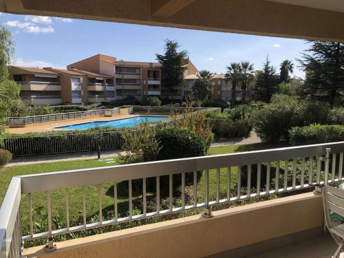 d'un balcon avec vue sur la piscine et les bâtiments. dans l'établissement Appartement Climatisé avec Terrasse et Piscine au Lavandou - FR-1-308-168, au Lavandou