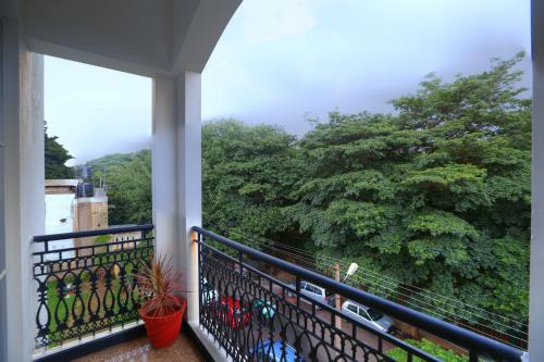 a balcony with a view of a tree at Lilac Hotel 3rd Block in Bangalore