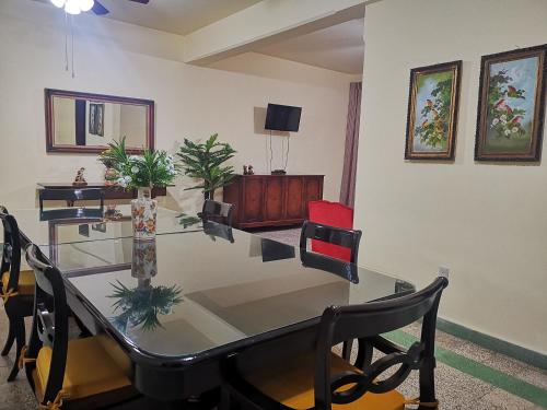 a dining room with a glass table and chairs at Departamento vintage in Papantla de Olarte