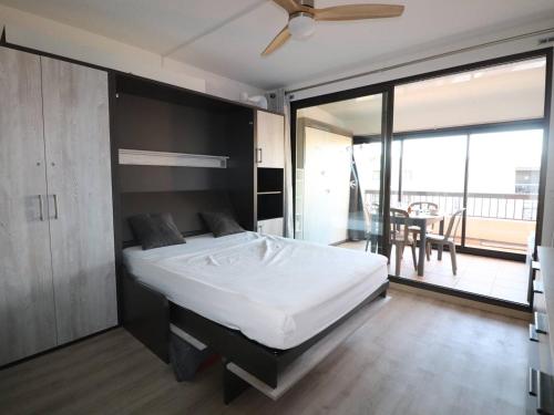 une chambre avec un grand lit et un balcon dans l'établissement Studio cabine équipé pour 4 pers avec parking privé à 2 min de la mer au Grau-du-Roi - FR-1-307-210, au Grau-du-Roi
