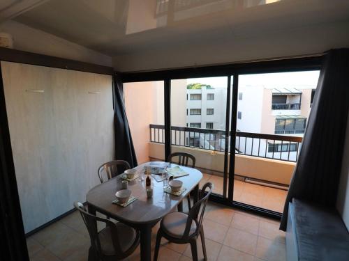 Cette chambre dispose d'un balcon avec une table et des chaises. dans l'établissement Studio cabine équipé pour 4 pers avec parking privé à 2 min de la mer au Grau-du-Roi - FR-1-307-210, au Grau-du-Roi