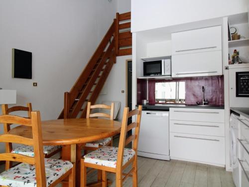 une cuisine et une salle à manger avec une table et des chaises en bois dans l'établissement Saint Cyprien - T3 lumineux avec plage, piscine collective et parking privé - FR-1-309-356, à Saint-Cyprien